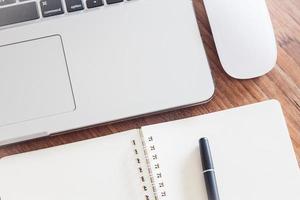 Close-up of a notebook with a pen and a laptop photo