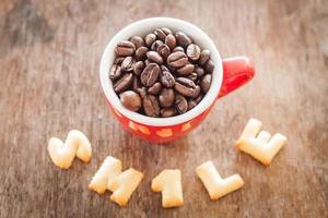 sonreír galletas del alfabeto con una taza de café roja foto