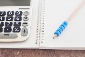 Calculator and pencil on a notebook photo