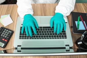 Person in protective suit working on computer photo