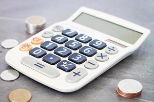 calculadora y monedas sobre un fondo gris