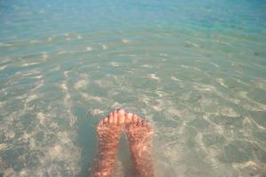 pies en agua clara del océano