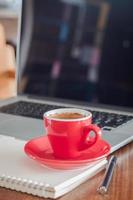 taza de café roja en una computadora portátil foto