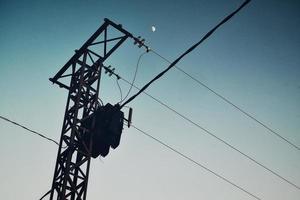 Moon and electrical power lines in the sky photo