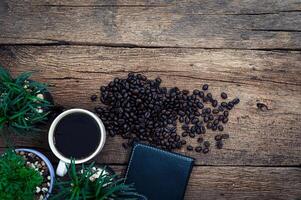 Coffee beans, a wallet, and a plant on a wooden table photo