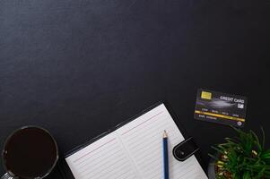 Notebook and credit card on black background photo