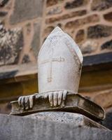 Brno, Czech Republic, 2020 - Sculpture of a pope hat on hands and a book photo