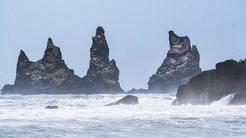 Black rock formations in the sea photo