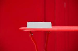 Recipiente de plástico blanco sobre una mesa roja foto