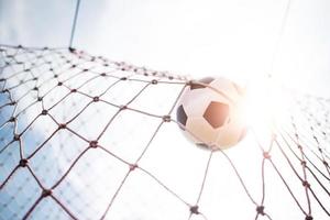 Soccer ball soars into goal net photo