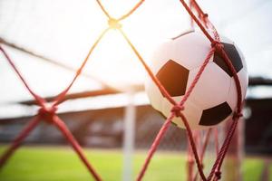 balón de fútbol se eleva a la red de la portería foto