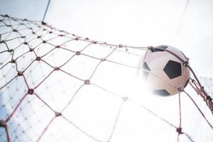 Soccer ball soars into goal net photo