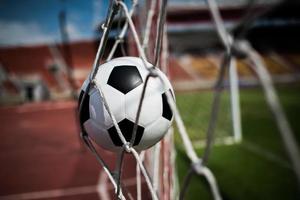 balón de fútbol se eleva a la red de la portería foto