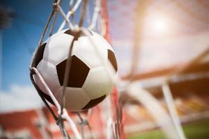 balón de fútbol se eleva a la red de la portería foto