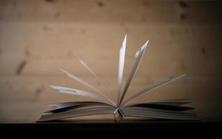 Close-up of an opened book on a wooden table photo