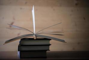 Stack of open books on a wooden table photo