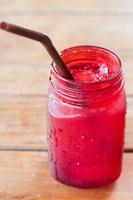 Iced drink in red glass with a straw photo