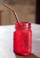 Red glass jar on a wooden table photo