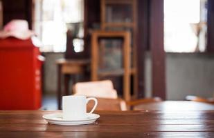 White coffee cup on a wooden table in a coffee shop photo