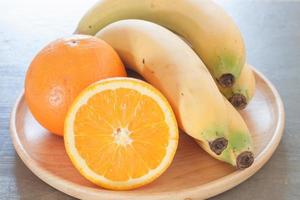 Close-up de un tazón de frutas con naranjas y plátanos foto