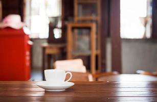 Coffee cup on a wooden table in a coffee shop photo