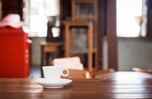 White coffee cup on a table in a coffee shop photo