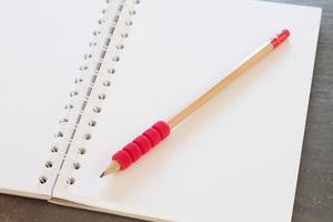 cuaderno con un lápiz rojo foto