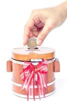 Hand putting a coin in a money box