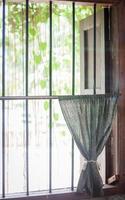 Curtain on a barred window photo
