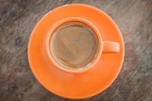 Top view of an orange coffee cup and saucer photo