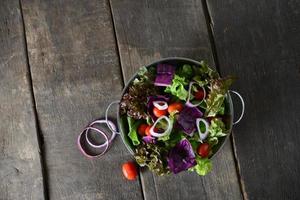 Ensalada de verduras frescas con fondo rústico de madera vieja foto