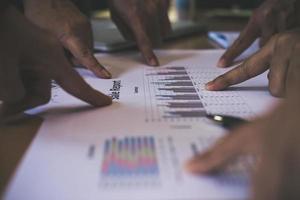 Group of business partners pointing to graph sheet photo