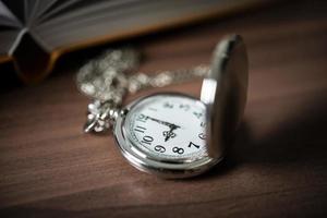 Close-up of a golden pocket watch and a book photo