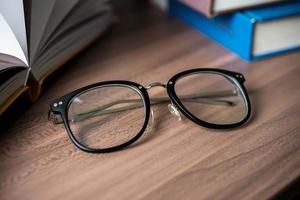 Glasses on a wooden table with books photo