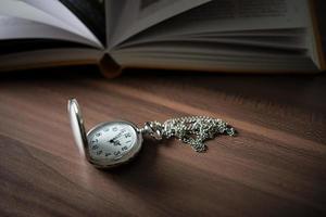 Close-up of a golden pocket watch and a book photo