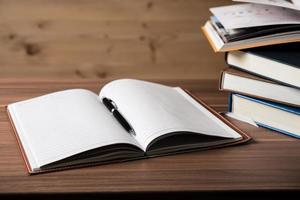 Stack of open books on a wooden table photo