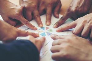 Group of business partners pointing to graph sheet photo