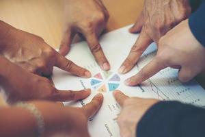 Group of business partners pointing to graph sheet photo