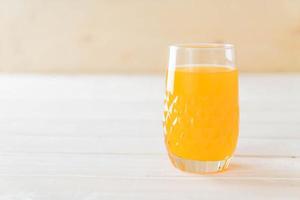 vaso de jugo de naranja sobre fondo blanco foto