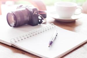 cuaderno con bolígrafo y cámara foto