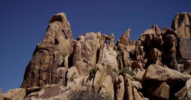panoramique lent montrant une petite colline de roches rouges dans un paysage désertique en 4k video