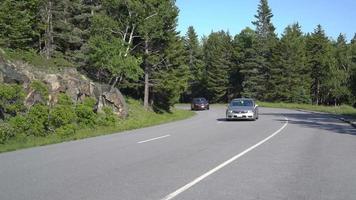 Vista de los coches que conducen por la esquina de la montaña 4k video