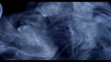 Close up of savage waves of white smoke moving from left to right on dark background in 4K video