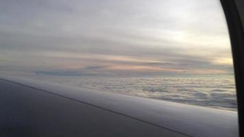 Vista de altosestratos y estratocúmulos nubes desde el interior de un avión con vistas a un ala al atardecer video