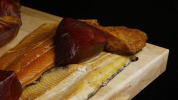 Rotating shot of a variety of delicious, premium smoked meats on a wooden cutting board - FOOD 079 video