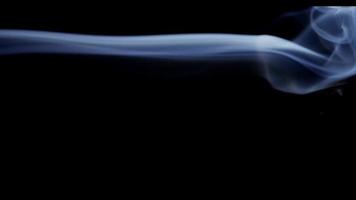 Close up of detail of white smoke moving and floating in darkness in 4K video