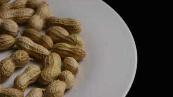 Cinematic, rotating shot of peanuts on a white surface - PEANUTS 008 video