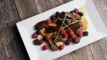 foto rotativa de um delicioso prato de bacon de pato defumado com abacaxi grelhado, framboesas, amoras e mel - comida 088