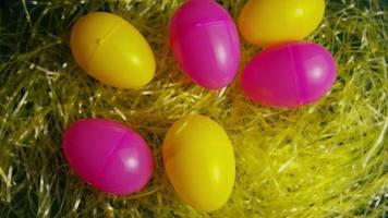 Tournage de décorations de Pâques et de bonbons dans l'herbe de Pâques colorée video