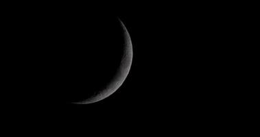 Dark waxing crescent moon moving in night sky from left to right in 4K video